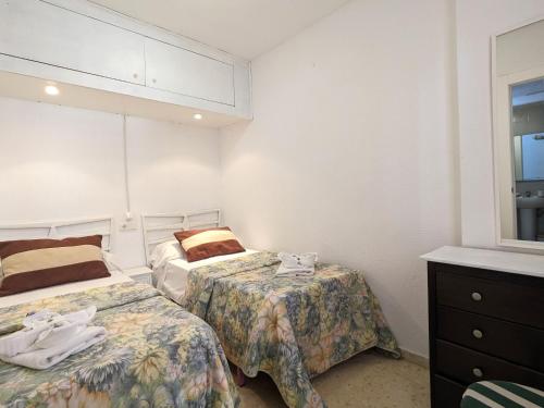 カーラ・デ・フィネストラットにあるApartment Don Miguel III by Interhomeのベッド2台とドレッサーが備わる客室です。