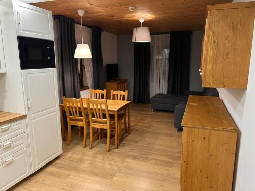 a kitchen and living room with a table and chairs at Apartmány Horský Dvůr in Bedřichov