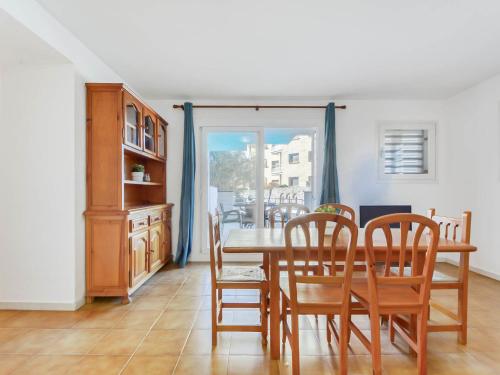 ein Esszimmer mit einem Holztisch und Stühlen in der Unterkunft Apartment Platja de Roses-7 by Interhome in Roses