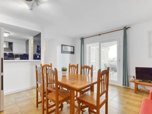 a dining room with a wooden table and chairs at Apartment Platja de Roses-9 by Interhome in Roses