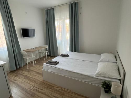 ein kleines Schlafzimmer mit einem Bett und einem Tisch in der Unterkunft Milutinn-Trešnja in Sokobanja