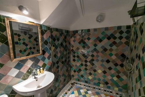 a bathroom with a sink and a mirror at Riad dar Yamna in Fès
