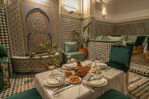a dining room with a table with plates of food at Riad dar Yamna in Fès