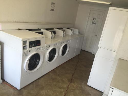 lavadero con lavadoras y secadoras blancas en Extended Stay Studios en Montgomery