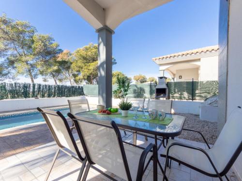 une terrasse avec une table, des chaises et une piscine dans l'établissement Holiday Home Gaviota 9 by Interhome, à Riumar