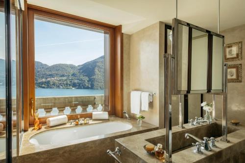 a bathroom with a tub and a large window at Grand Hotel Tremezzo in Tremezzo