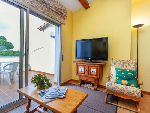 レスカラにあるApartment Residencial Gran Sol by Interhomeのリビングルーム(テレビ、椅子、テーブル付)