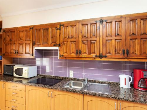 - une cuisine avec des placards en bois et un évier dans l'établissement Apartment Anfora 9 by Interhome, à Sant Martí d’Empúries
