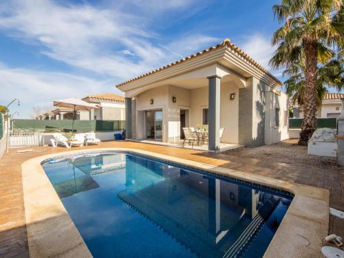 a swimming pool in front of a house at Holiday Home Gaviota 15 by Interhome in Riumar