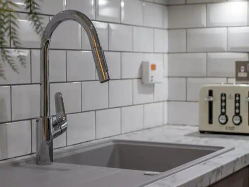 a kitchen sink with a faucet on a counter at Pass the Keys Comfortable and Fabulous Family Home in Newton Mearns