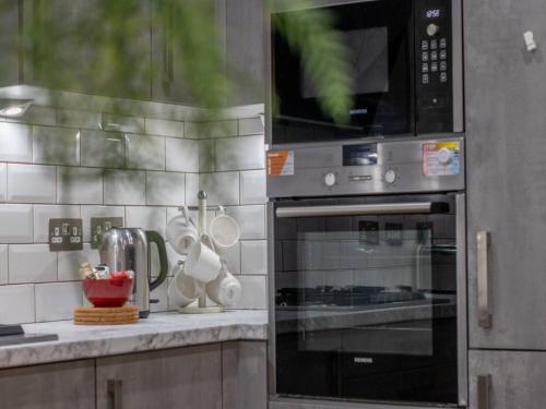 a microwave oven sitting on top of a kitchen counter at Pass the Keys Comfortable and Fabulous Family Home in Newton Mearns