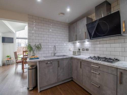 a kitchen with a sink and a stove top oven at Pass the Keys Comfortable and Fabulous Family Home in Newton Mearns