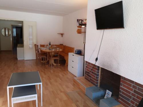 een woonkamer met een open haard en een televisie aan de muur bij Apartment Rosablanche A24 by Interhome in Siviez
