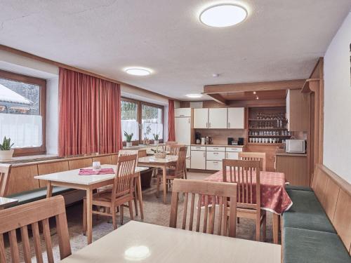 uma cozinha e sala de jantar com mesas e cadeiras em Holiday Home Wiese by Interhome em Oberlehn