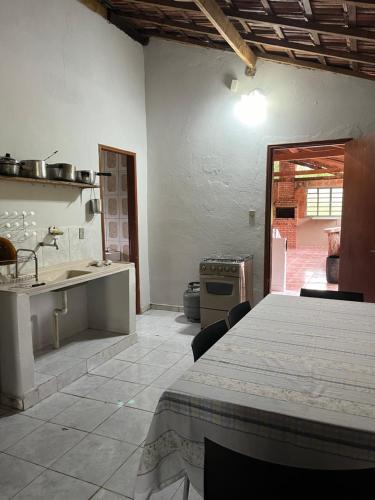a kitchen with a table and a sink and a stove at Casa na roça in São José do Barreiro