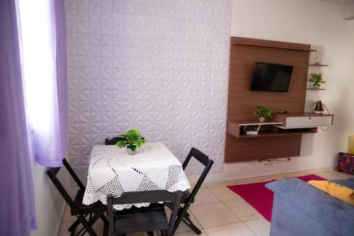a table and chairs in a room with a television at Apto otima localizacao e Wi-Fi em Serra ES in Serra