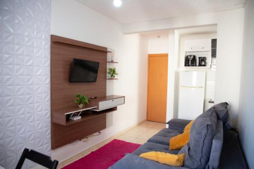 a living room with a blue couch and a tv at Apto otima localizacao e Wi-Fi em Serra ES in Serra