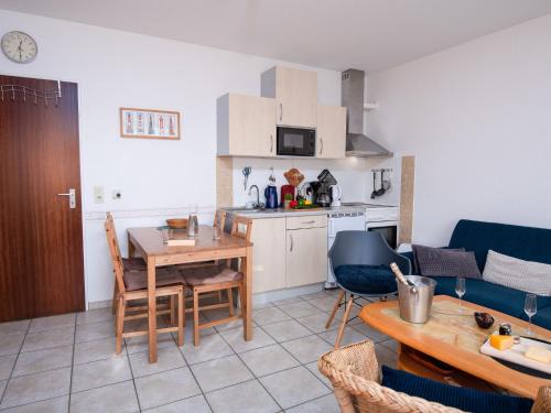 eine Küche und ein Wohnzimmer mit einem Tisch und einem Sofa in der Unterkunft Apartment Achtern Diek by Interhome in Norddeich