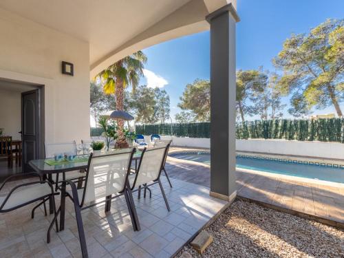 um pátio com uma mesa e cadeiras e uma piscina em Holiday Home Gaviota 7 by Interhome em Riumar