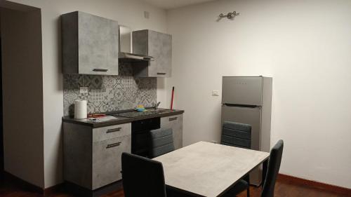 a small kitchen with a table and a refrigerator at Casa n 1 con parcheggio privato e colonnina ricarica in Livorno