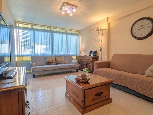 a living room with a couch and a clock on the wall at Apartment Don Lorenzo by Interhome in Benidorm