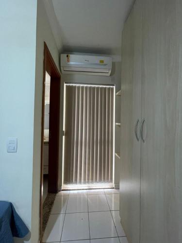 a hallway with a window with blinds on it at Edifício Belluno in Ribeirão Preto