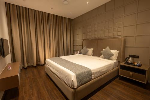 a bedroom with a bed in a hotel room at Hotel Parsons Court in Dindigul