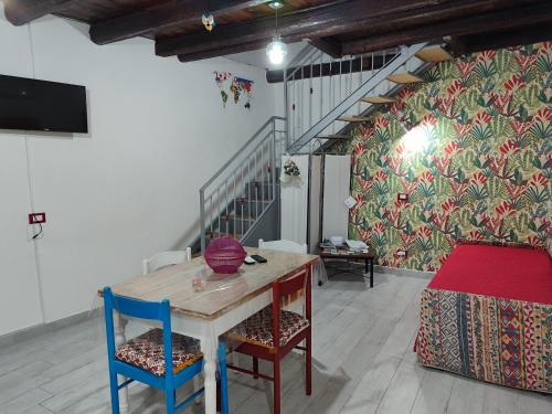 einen Tisch und Stühle in einem Zimmer mit einer Wand in der Unterkunft A' casuzza in Palermo