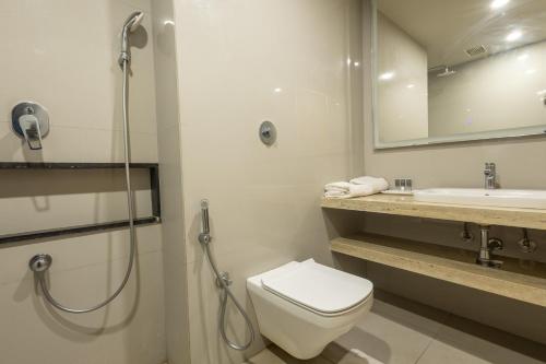 a bathroom with a shower and a toilet and a sink at Hotel Parsons Court in Dindigul