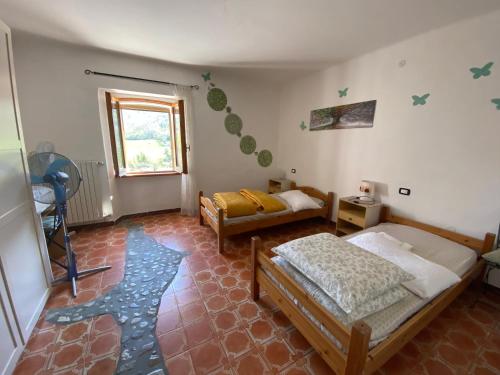 1 Schlafzimmer mit 2 Betten und einem Fenster in der Unterkunft Nicoletta Spirito del Tibet in San Leo