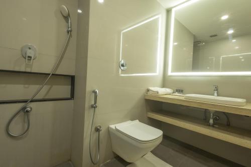 a bathroom with a toilet and a sink and a shower at Hotel Parsons Court in Dindigul