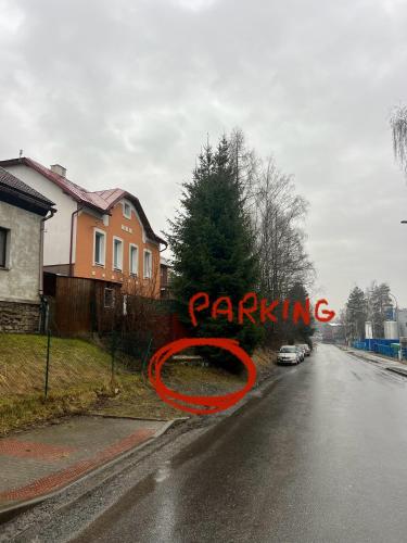 um sinal que diz estacionamento ao lado de uma estrada em Apartmán v Prvorepublikové vile em Žďár nad Sázavou