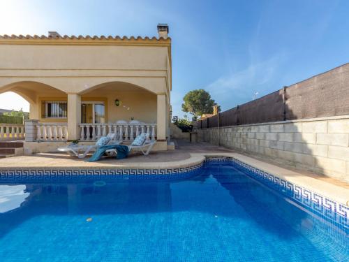 una piscina con 2 sillas junto a una casa en Holiday Home Teresa by Interhome, en Riumar