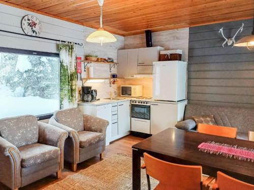 uma cozinha com mesa e cadeiras e uma sala de jantar em Holiday Home Mustalampi 4 kyyhkynen by Interhome em Ruka