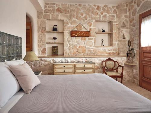 a bedroom with a large bed and a stone wall at Elegant Zante Villa - Villa Divas - 6 Bedrooms - Infinity Pool - 100 Metres To The Sea - Short Drive To Agios Nikolaos in Koríthion
