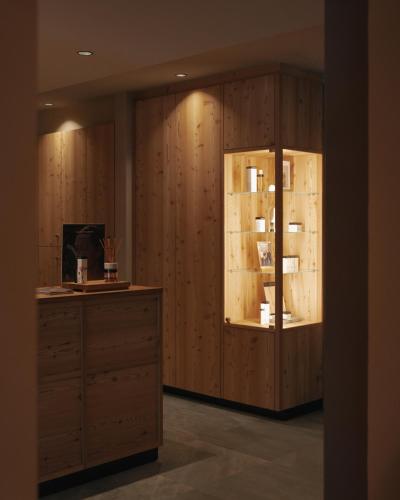 a dressing room with wooden cabinets and a desk at Brunelle Seiser Alm Lodge in Alpe di Siusi