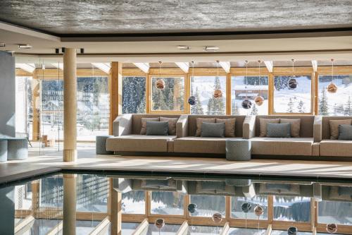 a living room with a couch and a swimming pool at Brunelle Seiser Alm Lodge in Alpe di Siusi