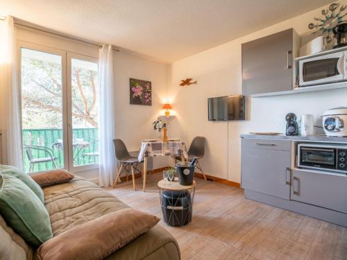 un salon avec un canapé et une cuisine dans l'établissement Studio Les Terrasses de la Mer-1 by Interhome, à Saint-Aygulf