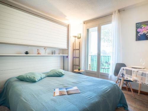 une chambre avec un lit avec deux livres dessus dans l'établissement Studio Les Terrasses de la Mer-1 by Interhome, à Saint-Aygulf