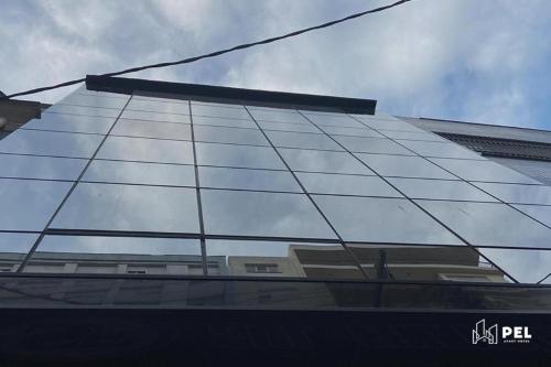 a glass facade of a building reflecting the sky at Pel Apart Hotel in Pelotas