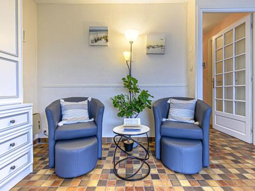 deux chaises bleues et une table dans une pièce dans l'établissement Apartment Les Embruns-1 by Interhome, à Carnac
