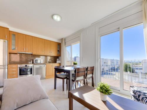 a kitchen and living room with a table and chairs at Apartment Puigmal by Interhome in Empuriabrava