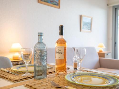 une bouteille de vin posée sur une table avec des verres dans l'établissement Studio Les Louvans-3 by Interhome, à Saint-Aygulf