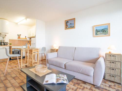 een woonkamer met een bank en een tafel bij Studio Les Louvans-3 by Interhome in Saint-Aygulf