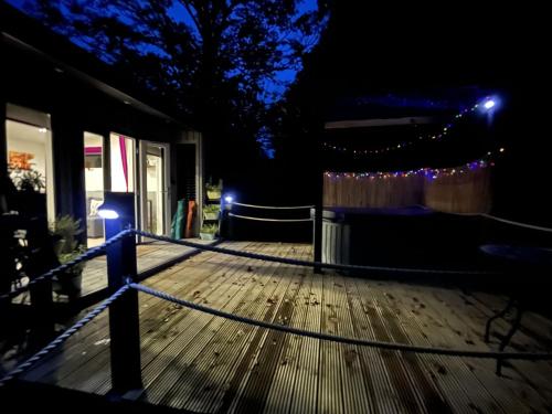 a deck at night with lights on it at Back to Nature Squirrels Lodge 1 bedroom lodge in South Molton