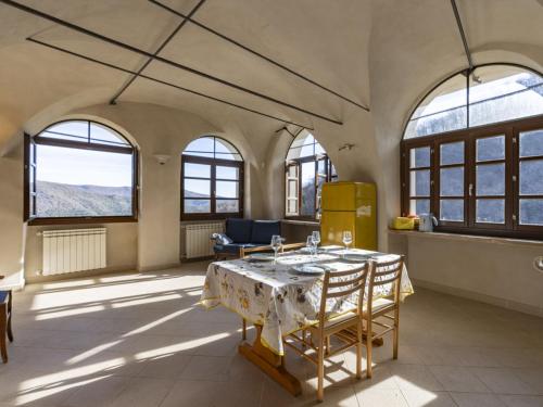 Habitación con mesa, sillas y ventanas. en Apartment Il Loggiato - TVE170 by Interhome, en Tavole
