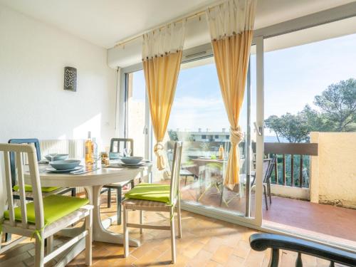 une salle à manger avec une table et des chaises et un balcon dans l'établissement Apartment Les Louvans-4 by Interhome, à Saint-Aygulf