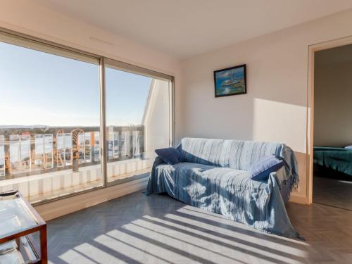ein Wohnzimmer mit einem Sofa und einem großen Fenster in der Unterkunft Apartment Cap Cabourg-22 by Interhome in Cabourg