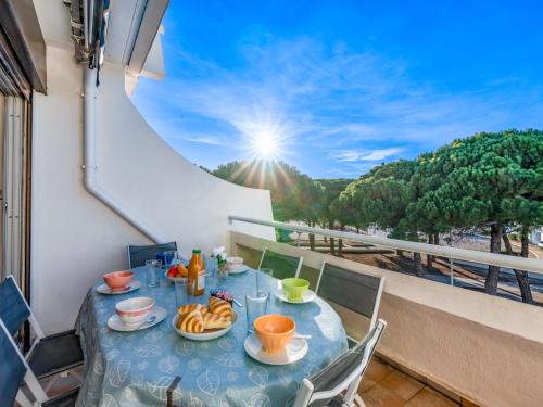 - une table avec des assiettes de nourriture sur un balcon avec vue dans l'établissement Apartment Le Flamant-4 by Interhome, au Grau-du-Roi