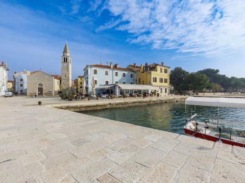a boat is docked next to a river with buildings at Apartment Villa Fasana by Interhome in Fažana